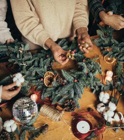 hands of women making Christmas wreaths using natural pine branches