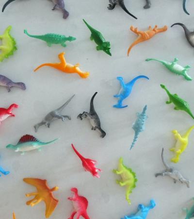 Photograph of small multi-colored dinosaur toys.