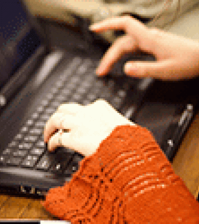 Close-up of hands typing on a laptop