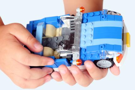 LEGO blue roadster in child's hands