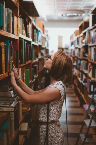 A woman looks for a book in the stacks. 
