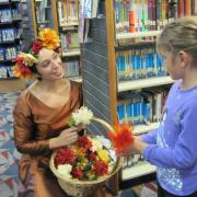 A staff member gives a girl flowers.
