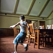 A boy runs around a table while playing laser tag in the library.