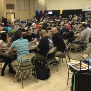 Large space filled with people playing games at tables