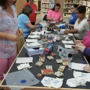 The participants use stamps to decorate linen gift bags.