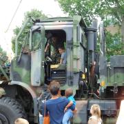 Boy getting a tour of military vehicle 