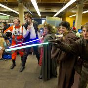Cosplayers in costume, holding light sabers