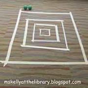 A Skeeball game board taped to the floor, and two balls (from the activity "Tape Games")