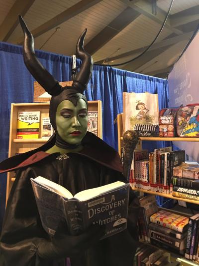 Maleficent reading a book at the booth
