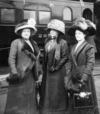 Suffragettes Mrs. Fred Lorenz, Mrs. Ella S. Stewart, and Miss Bertha Seass standing on a railroad platform.  Chicago History Museum