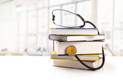 Stethoscope wrapped around a stack of books