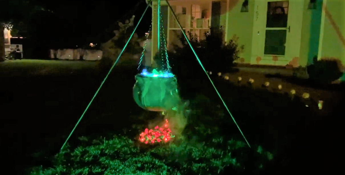 Photograph of the finished cauldron. The cauldron is glowing green in the dark with orange embers underneath.