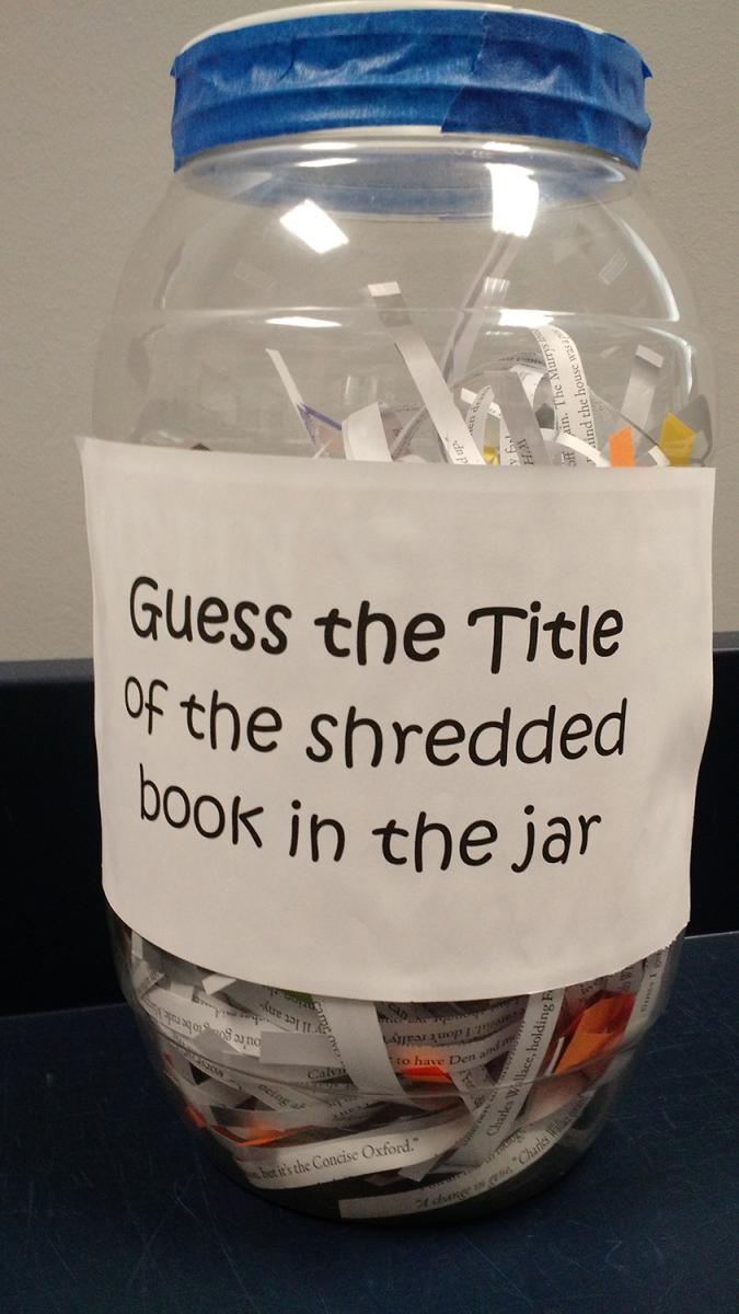 A jar with a label that reads "guess the title of the shredded book in the jar"