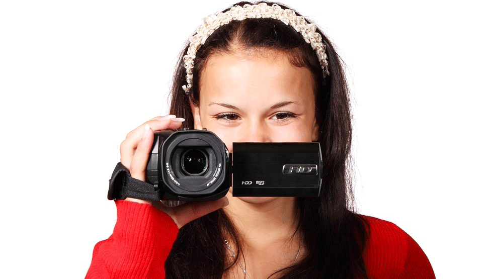 Girl holds camcorder in front of her face