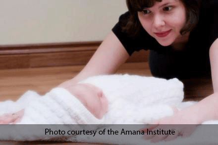 Woman doing child's pose with baby