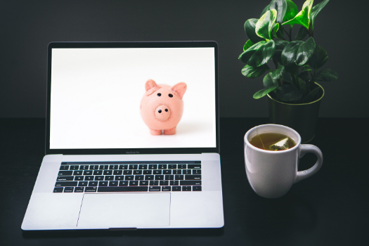 Photo of an open laptop with an image on a piggy bank on the screen