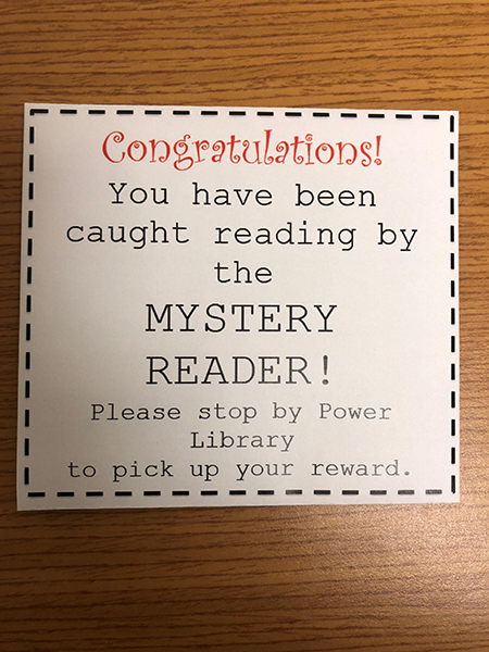 Slip that reads "Congratulations! You have been caught reading by the mystery reader! Please stop by Power Library to pick up your reward."