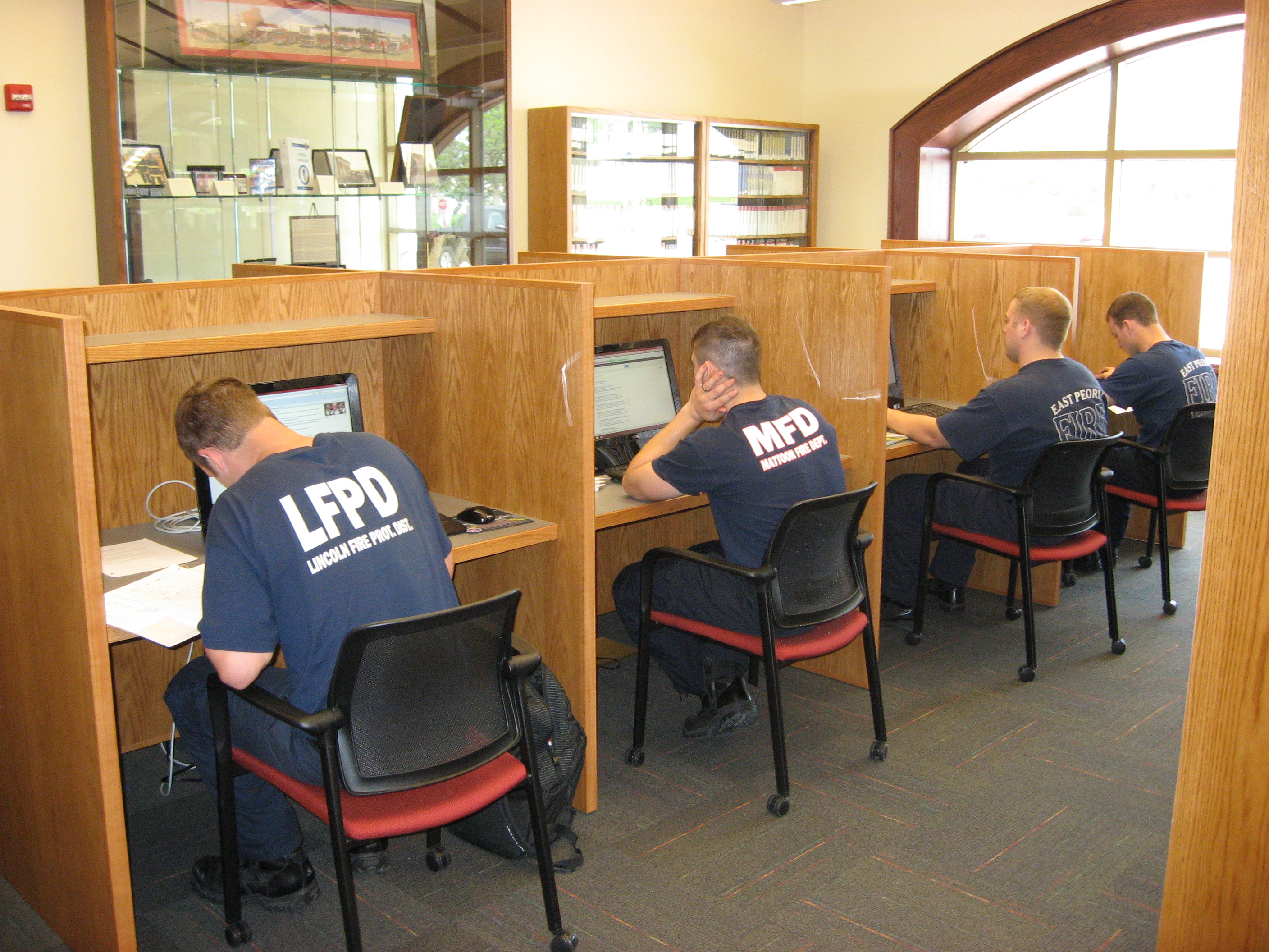 Photograph of firefighters using computer stations inside the Illinois Fire Service Institute Library