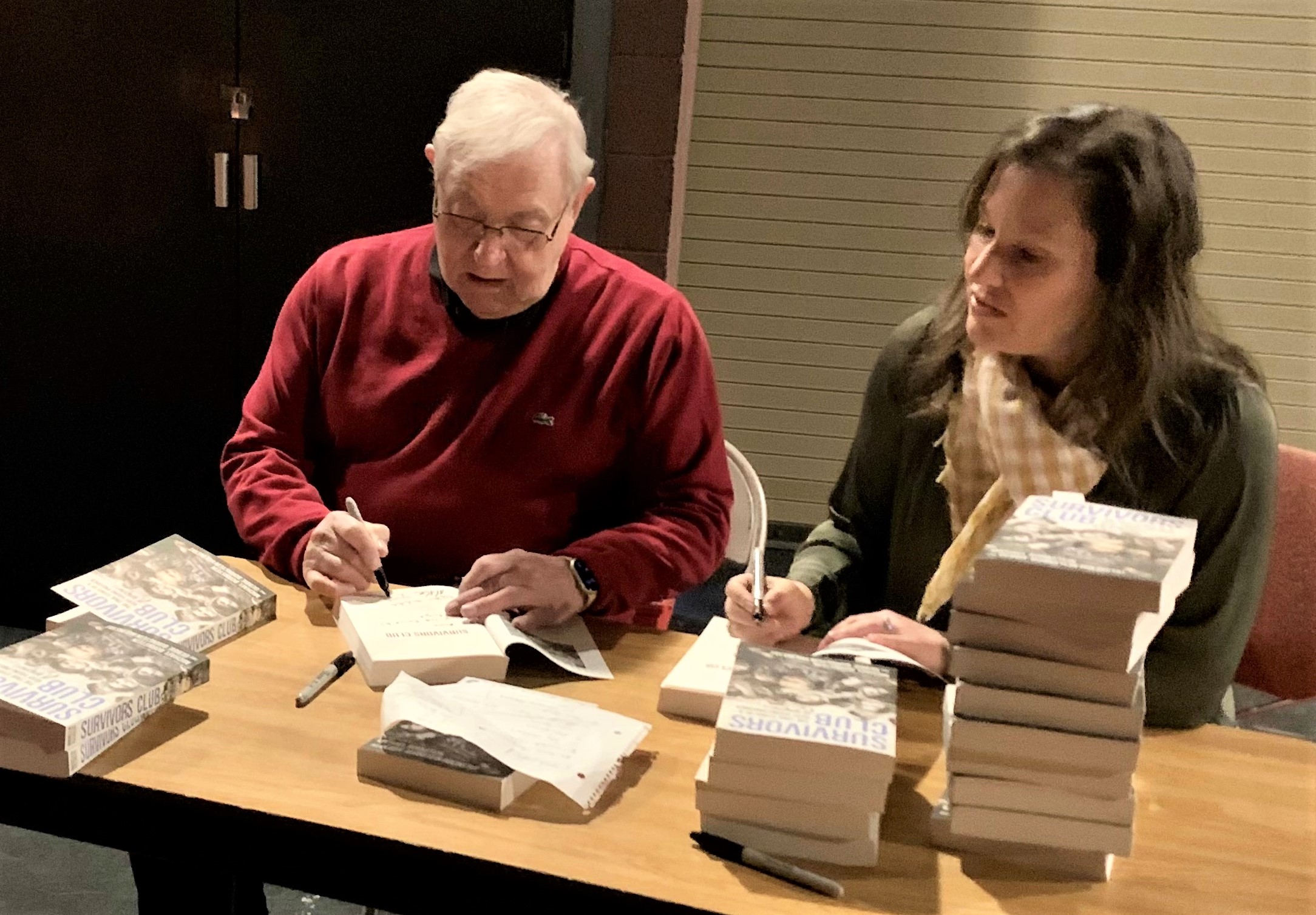 Photo shows Michael Bornstein and Debbie Bornstein Holinstat signing copies of “Survivors Club: The True Story of a Very Young Prisoner of Auschwitz" at Marshalltown Public Library.