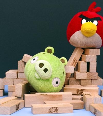 Angry Bird vs. Bad Piggies plush toys nestled in remains of Jenga tower