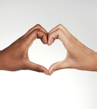 cropped photo of two women forming a heart with their hands
