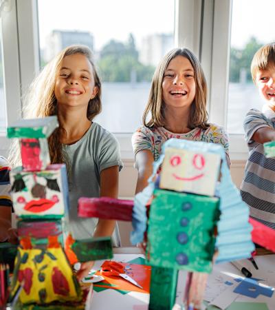 group of happy kids doing crafts at the library