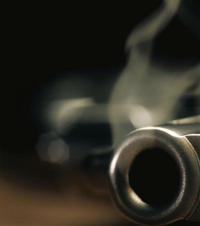 close-up of smoking gun on dark background