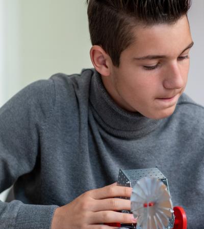 teenage boy concentrates on robotics project