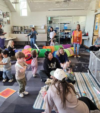 Babies and their caregivers dance around the Baby Rave room