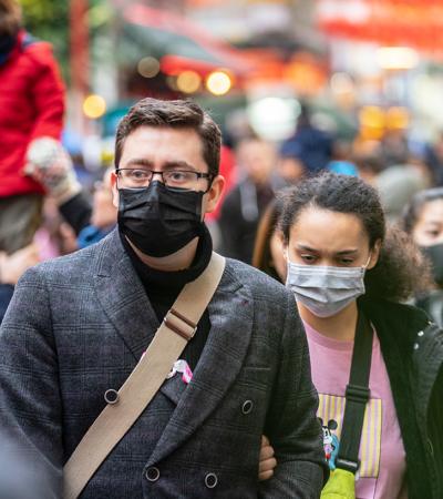 people walking in a crowd wearing face masks