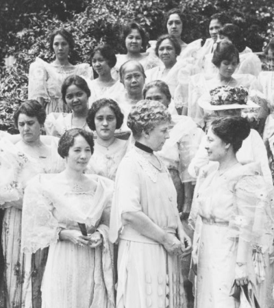 Black and white photograph from the LOC shows a group of women standing. Presented by Mme. Jaime C. De Veyra, the wives of the Philippine delegation who are seeking the recognition of complete independence of the islands, were received by Mrs. Harding at the White House. In the center of the group are Mrs. Harding and Mme. De Veyra.