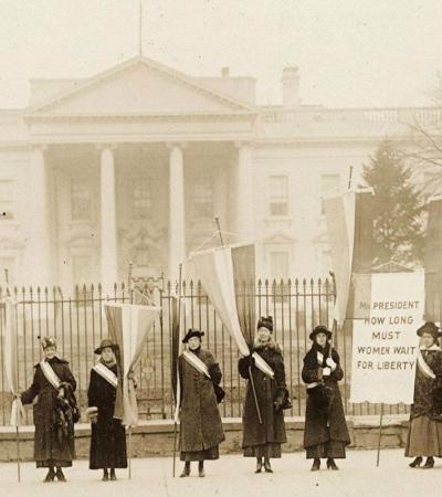 Black and white photo of suffragettes in front of the white house.