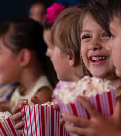 kids watching a movie with popcorn