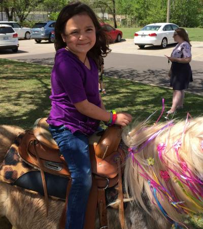 A girl on a horse decorated as a unicorn