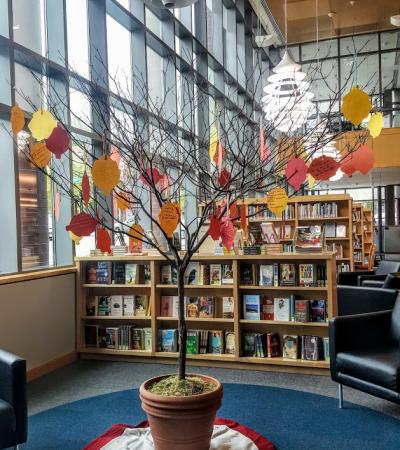 Picture of tree in library with paper leaves hanging