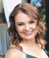 woman with brown curly hair smiling at camera