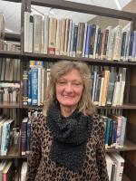 woman smiling in front of book shelf