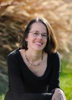 Picture of woman with glasses, dark hair, and smiling. 