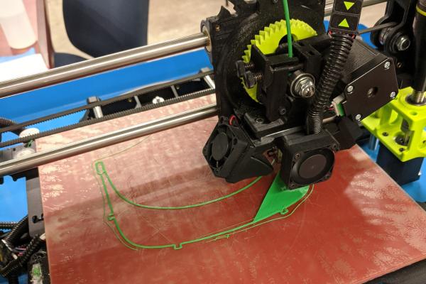 A 3D printer making face shields for PPEs.