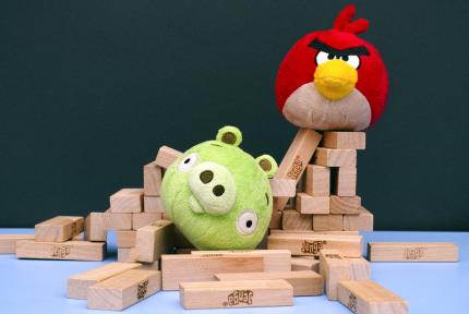 angry bird and bad piggy with fallen Jenga tower Angry Bird vs. Bad Piggies plush toys nestled in remains of Jenga tower
