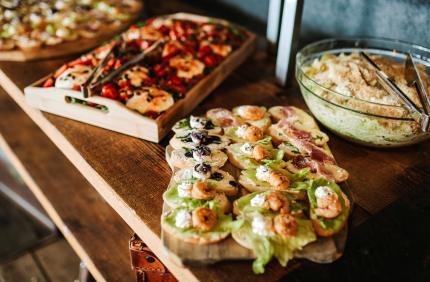 close up of trays of finger foods arranged on wooden surface