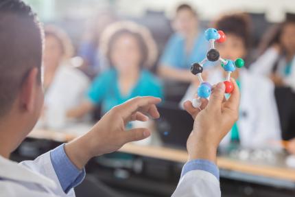 science professor teaches audience about molecules