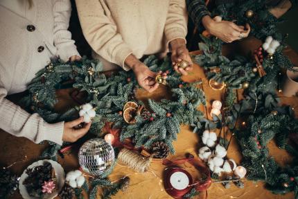 wreath-making hands of women making Christmas wreaths using natural pine branches