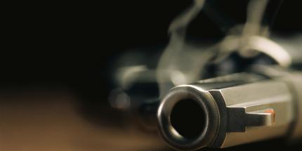 close-up of smoking gun on dark background