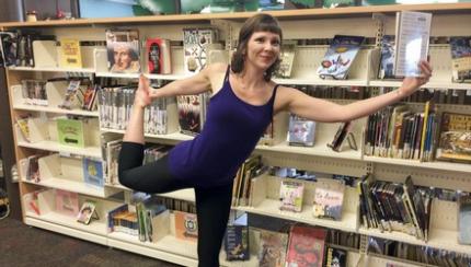 Yoga promotes literacy at the Fredericton Public Library Woman holds a book while balancing in dancer pose at the Fredericton Public Library
