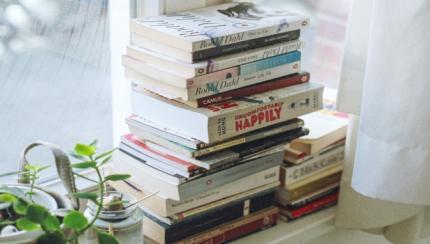 Stack of books on windowsill.
