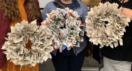 Patrons holding up completed book wreaths