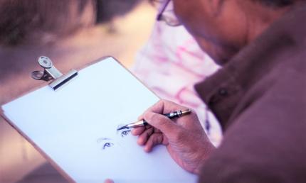 Photograph of person drawing a pair of eyes.