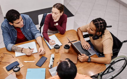 Photograph of a group of young people studying together at table in a library