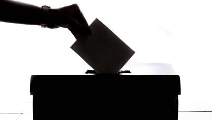 hand putting ballot in box hand putting ballot in box